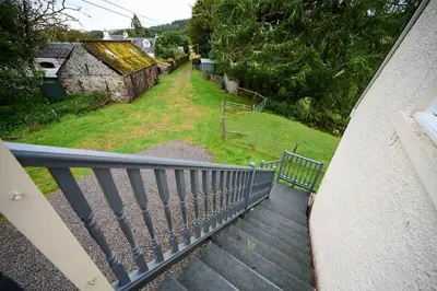 a balcony with a view of a yard and a house at Rural 1-Bed Retreat at Stunning Raera Farm in Kilninver