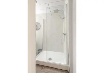 a bathroom with a shower with a white tub at Elegant Flat in a Serene Edinburgh Neighbourhood in Edinburgh
