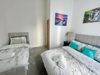 a bedroom with two beds and a picture on the wall at Three bedroom Apartment In Glasgow City Centre in Glasgow