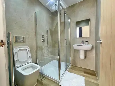 a bathroom with a shower and a toilet and a sink at Three bedroom Apartment In Glasgow City Centre in Glasgow