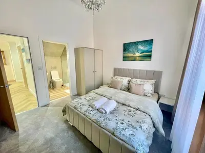 a bedroom with a large bed with a chandelier at Three bedroom Apartment In Glasgow City Centre in Glasgow