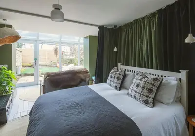 a bedroom with a bed and a chair and a window at Shipmaster's Townhouse in Queensferry
