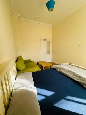 a bedroom with a bed and a couch at Cozy Room In Sauchiehall Street in Glasgow