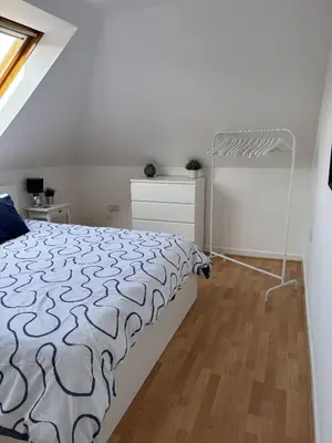a white bedroom with a bed and a wooden floor at Skibo Vista Dunfermline in Dunfermline