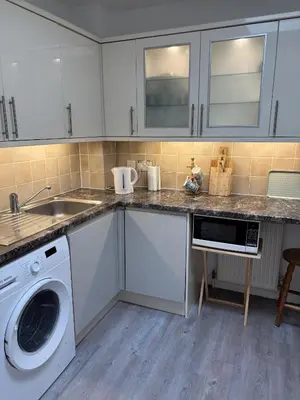 a kitchen with a sink and a washing machine at Skibo Vista Dunfermline in Dunfermline