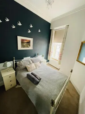a bedroom with a bed with birds on the wall at Lovely 2 bedroom apartment in Ayr town centre in Ayr