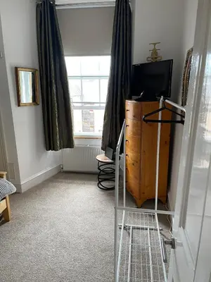 a room with a television and a dresser and a window at Lovely 2 bedroom apartment in Ayr town centre in Ayr