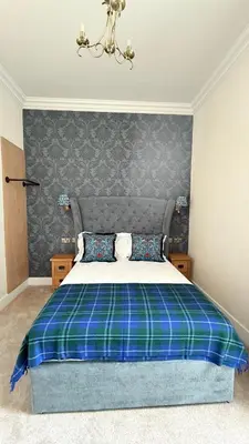 a bedroom with a bed with a blue and green blanket at Armadillo Guest House- Adults Only in Edinburgh