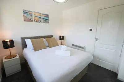 a bedroom with a large white bed and a lamp at Modern 2 Bedroom Platinum Pad Glasgow City in Glasgow