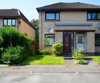 a brick house with a brown door and grass at Modern 2 Bedroom Platinum Pad Glasgow City in Glasgow
