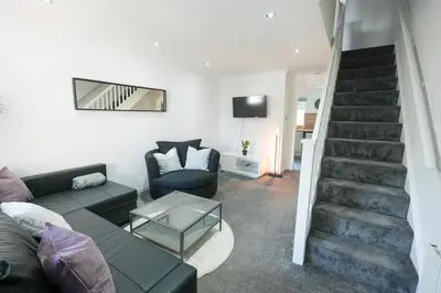 a living room with a couch and a staircase at Modern 2 Bedroom Platinum Pad Glasgow City in Glasgow