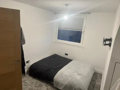 a bedroom with a bed in a room with a window at Stylish modern flat in the centre of Dunfermline in Dunfermline
