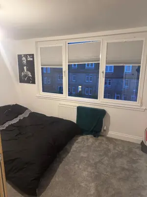 a bedroom with a bed and two windows at Stylish modern flat in the centre of Dunfermline in Dunfermline