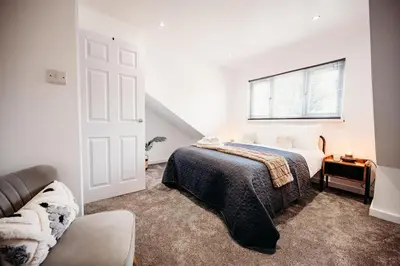 a white bedroom with a bed and a window at 4 Bed Sheffield home in Moffat