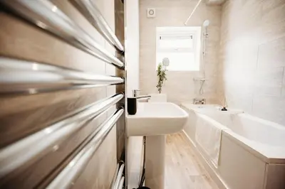 a bathroom with a sink and a bath tub at 4 Bed Sheffield home in Moffat