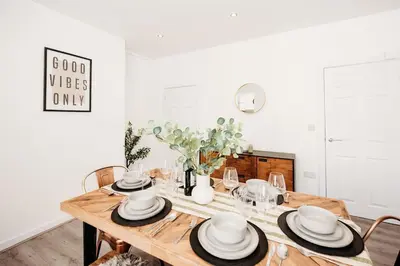 a dining room with a wooden table with hats on it at 4 Bed Sheffield home in Moffat