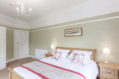 a bedroom with a large white bed with two pillows at Lonan Country House and Gardens in Taynuilt