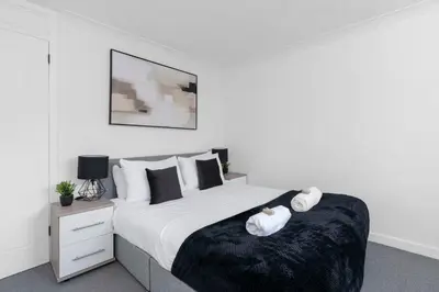 a bedroom with a bed with two towels on it at Livingston Retreat 4bed Home Wi-Fi Parking in Uphall