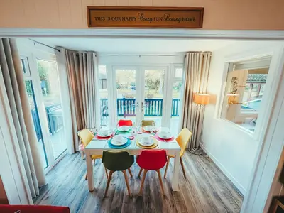 a dining room with a table and four chairs at Highland Coo Lodge in Dunoon
