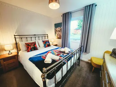a bedroom with a bed with two teddy bears on it at Highland Coo Lodge in Dunoon