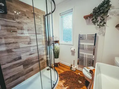 a bathroom with a shower and a leopard rug at Highland Coo Lodge in Dunoon