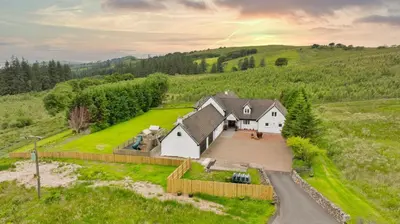 an aerial view of a white house in a field at Finest Retreats - Grassyards House in Largs