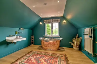 a bathroom with a large tub and a sink at Finest Retreats - Grassyards House in Largs