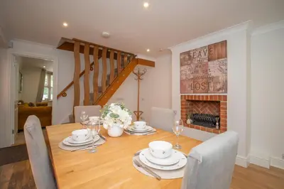 a dining room with a table with chairs and a fireplace at Spacious 3 Bedroom home in Ascot, Sleeps 5, Parking in Moffat