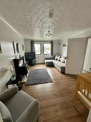 a living room with a couch and a table at Loch Lomond Apartment in Balloch