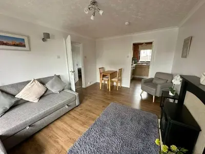 a living room with a couch and a dining room at Loch Lomond Apartment in Balloch