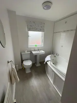 a bathroom with a tub and a toilet and a sink at Loch Lomond Apartment in Balloch