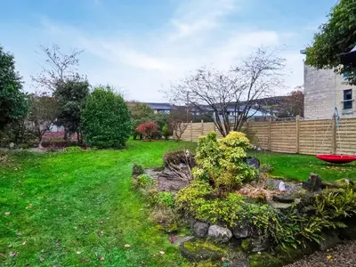 a yard with a fence and green grass at Monawilline Cottage in Lamlash