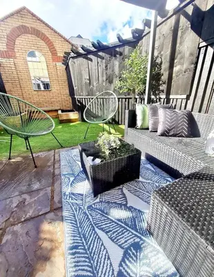 a patio with a couch and a table and chairs at Urban 4BR house - Central-FREE parking-NO PARTY in Glasgow