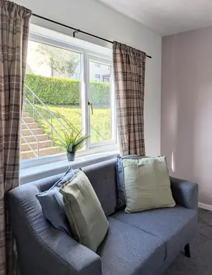 a blue couch in a living room with a window at Kintyre House in Campbeltown