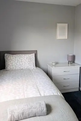 a bedroom with a bed and a white dresser and a drawer at Kintyre House in Campbeltown