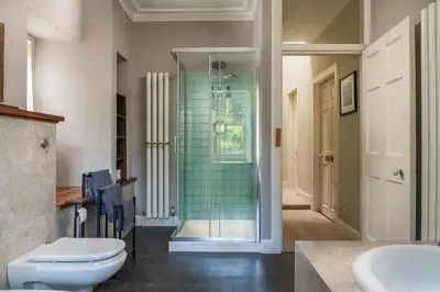 a bathroom with a toilet and a glass shower at Quarter House in Peebles
