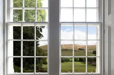 two windows with views of a golf course seen through them at Quarter House in Peebles