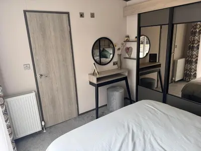 a bedroom with a bed and a mirror at Lime Tree Lodge in Crieff