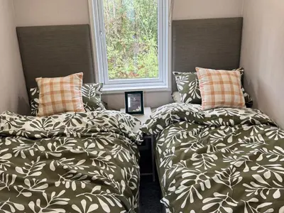 two beds sitting next to each other in a bedroom at Lime Tree Lodge in Crieff