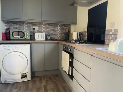 a kitchen with a dishwasher and a washer at The Wee Flat in Uphall