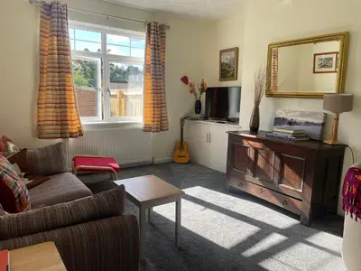 a living room with a couch and a table and a mirror at The Wee Flat in Uphall