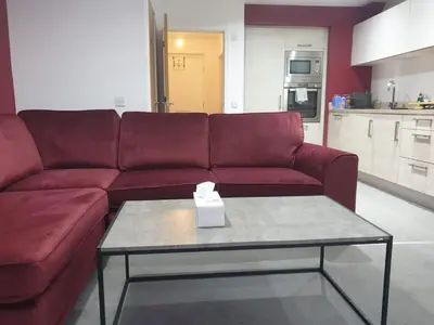 a living room with a red couch and a table at Oatlands Oasis-FREE PARKING-2 Minutes from M74 in Glasgow