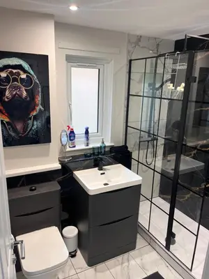 a bathroom with a dog painting on the wall at Hutchison apartments in Edinburgh