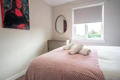 a bedroom with a bed with two pillows on it at California House in Falkirk