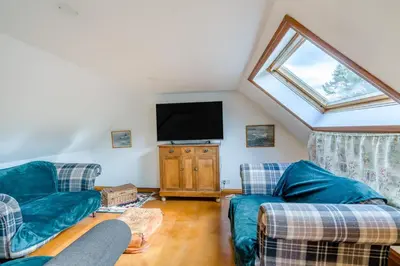 a living room with two couches and a flat screen tv at 3 Bed in Comrie oc-e33307 in Comrie