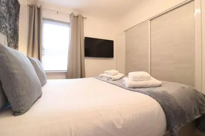 a bedroom with a bed with towels on it at Cosy 1 bed flat in central Ayr in Ayr