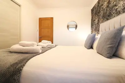 a bedroom with a large bed with towels on it at Cosy 1 bed flat in central Ayr in Ayr