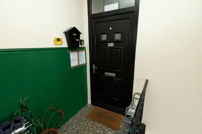 a black door with a bench in front of it at Troon - Coastal Getaway in Troon
