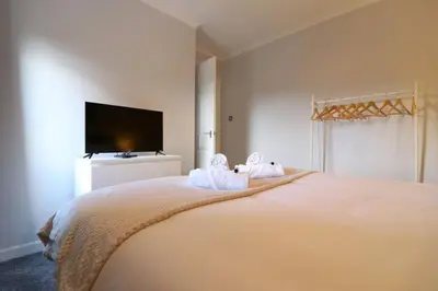 a bedroom with a large bed with towels on it at Lovely 2 BR flat, sleeps 4 in Chapelhall