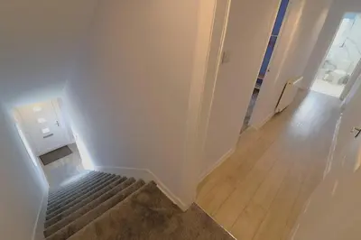 an empty hallway with a stairway with a stair case at Lovely 2 BR flat, sleeps 4 in Chapelhall